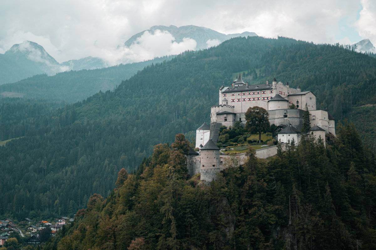 Hohenwerfen Castle in Austria with trees and clouds behind.